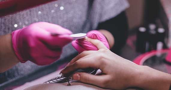 Nail technician painting women&#39;s nails.